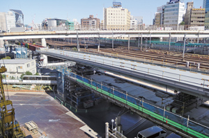 写真-2　作業構台上の箱桁（手前）と手延べ機（左奥）